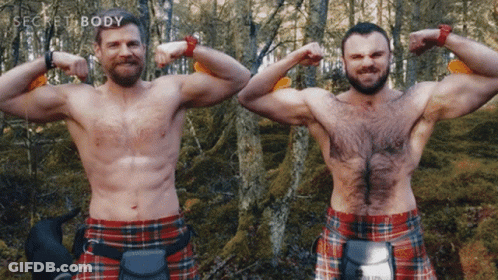 Two Men In Kilts Flex Their Muscles In Front Of Trees With The Words Secret Body Behind Them GIF