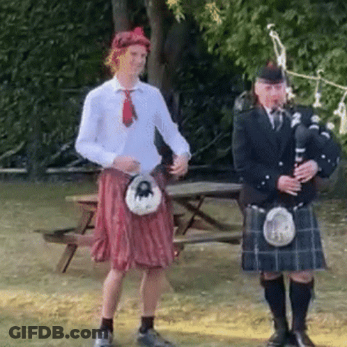 Two Men In Kilts One Playing Bagpipe GIF