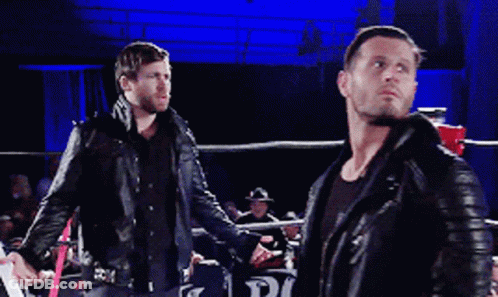 Two Men In Leather Jackets Are Standing In A Boxing Ring Talking To Each Other GIF
