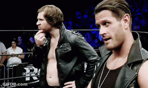 Two Men In Leather Jackets Are Standing In A Ring With The Letter R On The Fence GIF