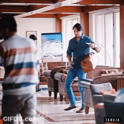 Two Men In Living Room With Tanuja Logo GIF