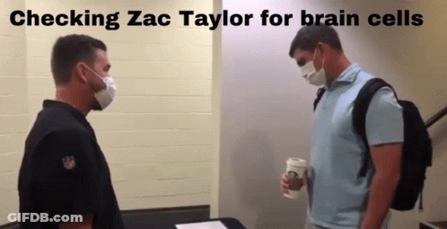 Two Men In Masks Checking Zac Taylor For Brain Cells GIF