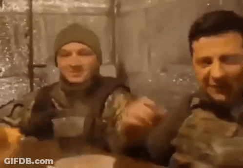 Two Men In Military Uniforms Are Sitting At A Table And Eating Food . GIF
