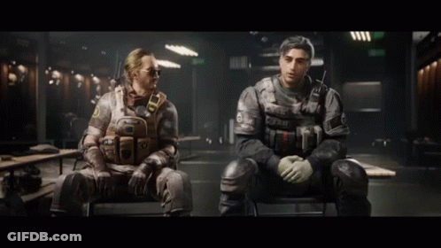 Two Men In Military Uniforms Are Sitting In Chairs In A Dark Room . GIF