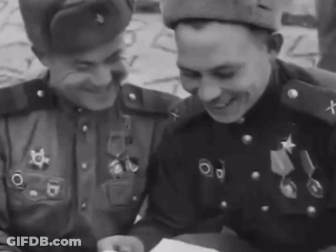 Two Men In Military Uniforms Are Smiling And Looking At Something GIF