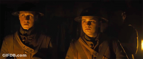 Two Men In Military Uniforms Are Standing Next To Each Other In The Dark GIF