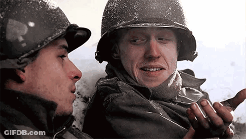 Two Men In Military Uniforms Are Talking To Each Other In The Snow . GIF