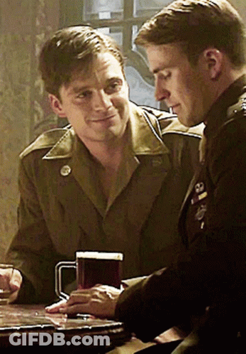 Two Men In Military Uniforms Sitting With Beer GIF
