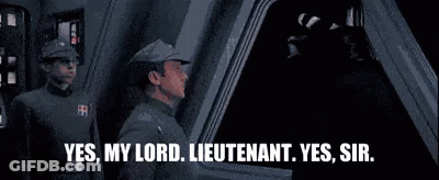Two Men In Military Uniforms Talking In Dark Room GIF