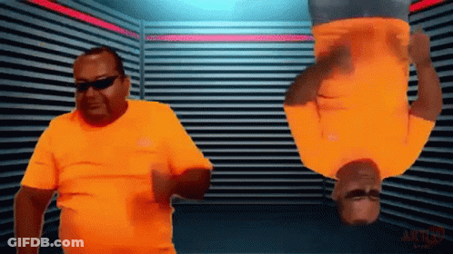 Two Men In Orange Shirts Are Upside Down In A Room With A Sign That Says Action GIF