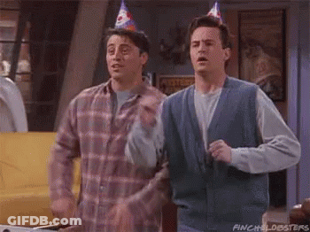 Two Men In Party Hats Standing Together GIF