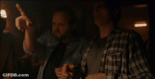 Two Men In Plaid Shirts Sitting Hands On Chests GIF