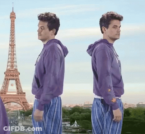 Two Men In Purple Sweatshirts Are Standing In Front Of The Eiffel Tower In Paris GIF