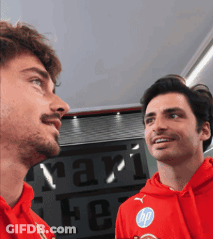 Two Men In Red Sweatshirts In Front Of Ferrari Sign GIF