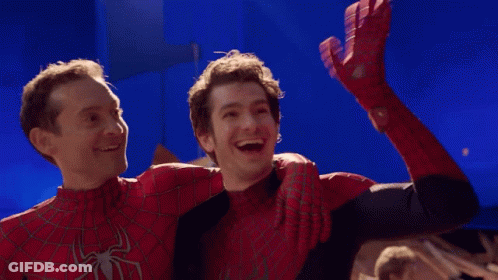 Two Men In Spiderman Costumes Are Hugging Each Other And Smiling GIF