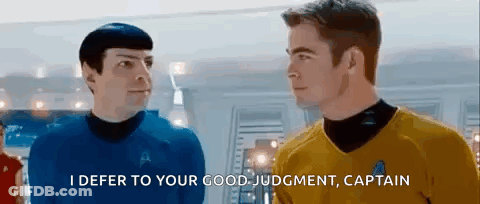 Two Men In Star Trek Uniforms Are Standing Next To Each Other . GIF