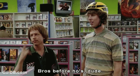 Two Men In Store One Wearing Helmet Talking GIF