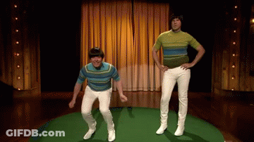 Two Men In Striped Shirts And White Pants Are Jumping In The Air On A Stage GIF