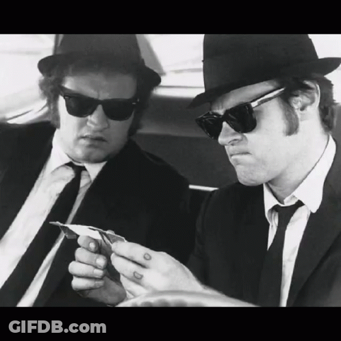 Two Men In Suits And Hats Are Playing Cards GIF