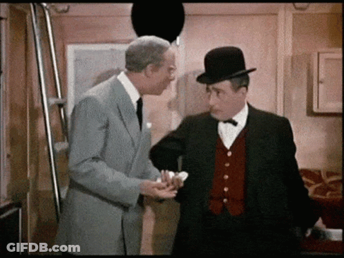 Two Men In Suits And Hats Are Standing Next To Each Other And Talking GIF