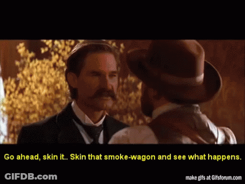 Two Men In Suits And Hats Are Talking To Each Other And The Caption Says Go Ahead Skin It GIF