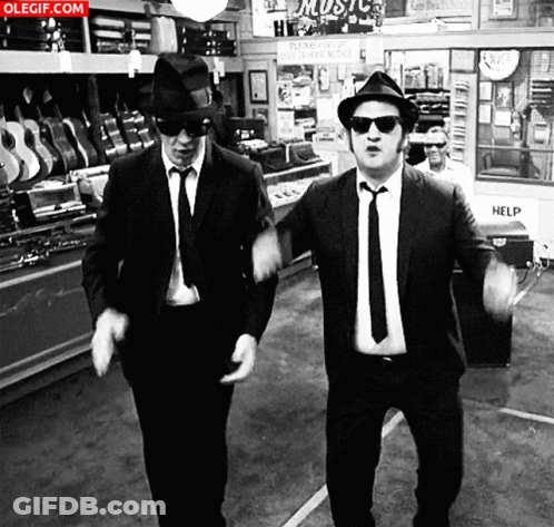 Two Men In Suits And Hats Dancing In Front Of Music Store GIF