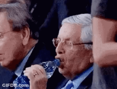 Two Men In Suits And Ties Are Drinking Water From A Bottle . GIF