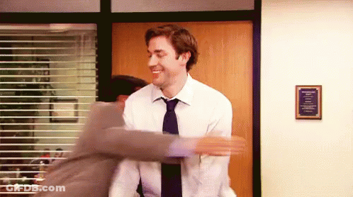 Two Men In Suits And Ties Are Hugging Each Other In An Office . GIF