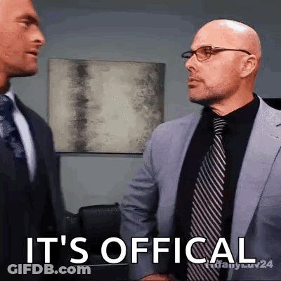 Two Men In Suits And Ties Are Shaking Hands And One Of Them Says It 'S Official GIF