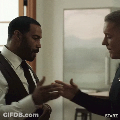 Two Men In Suits And Ties Are Shaking Hands In A Starz Advertisement . GIF