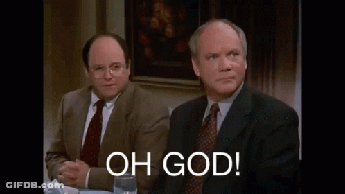 Two Men In Suits And Ties Are Sitting At A Table With A Glass Of Wine And A Sign That Says `` Oh God '' . GIF