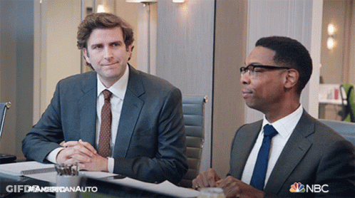 Two Men In Suits And Ties Are Sitting At A Table With A Nbc Logo On The Bottom GIF