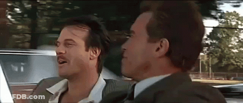 Two Men In Suits And Ties Are Sitting In A Car And Talking To Each Other . GIF