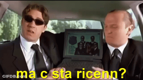 Two Men In Suits And Ties Are Sitting In A Car Looking At A Laptop Screen That Says Ma C Sta Ricenn? GIF