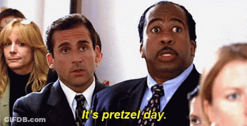 Two Men In Suits And Ties Are Sitting In Front Of A Crowd Of People . GIF