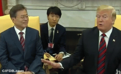 Two Men In Suits And Ties Are Sitting Next To Each Other Talking . GIF