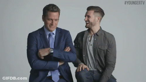 Two Men In Suits And Ties Are Sitting Next To Each Other With Their Arms Crossed .. GIF