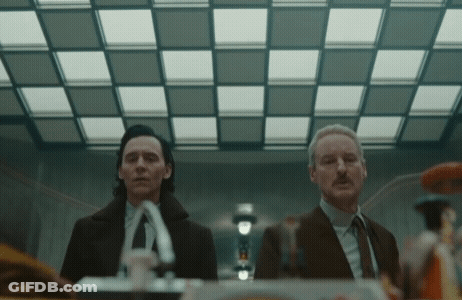 Two Men In Suits And Ties Are Standing Next To Each Other GIF