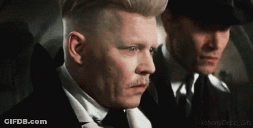 Two Men In Suits And Ties Are Standing Next To Each Other And Looking At Something . GIF