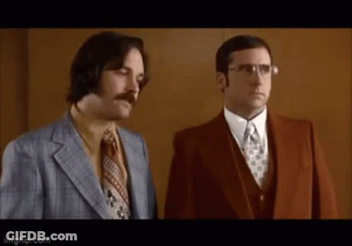 Two Men In Suits And Ties Are Standing Next To Each Other And Looking At Something . GIF