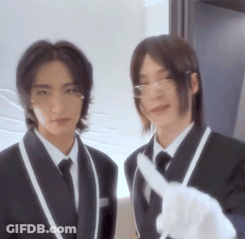 Two Men In Suits And Ties Are Standing Next To Each Other And One Is Pointing At The Camera GIF