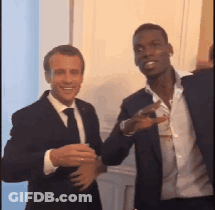 Two Men In Suits And Ties Are Standing Next To Each Other And Smiling GIF