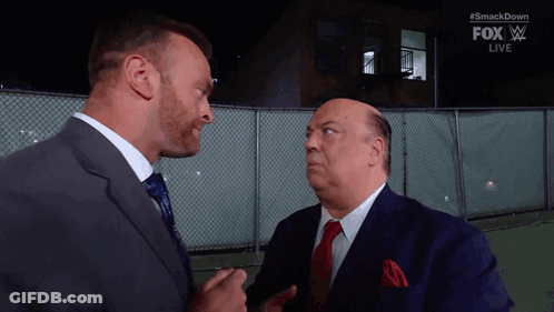 Two Men In Suits And Ties Are Standing Next To Each Other And Talking . GIF