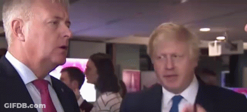 Two Men In Suits And Ties Are Standing Next To Each Other In A Room . GIF