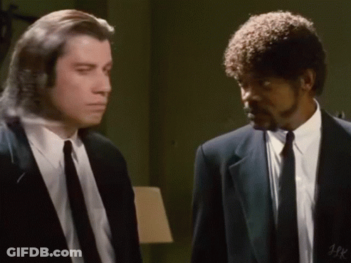 Two Men In Suits And Ties Are Standing Next To Each Other In A Room And Talking . GIF