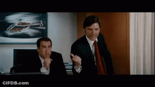 Two Men In Suits And Ties Are Standing Next To Each Other In An Office With A Helicopter In The Background . GIF