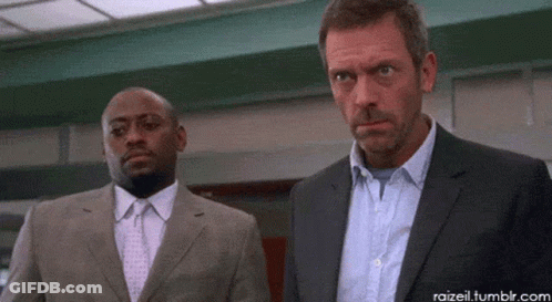 Two Men In Suits And Ties Are Standing Next To Each Other Looking At Something GIF