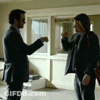 Two Men In Suits And Ties Are Standing Next To Each Other Talking GIF