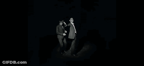 Two Men In Suits And Ties Are Standing Next To Each Other With Their Arms Outstretched . GIF