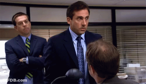 Two Men In Suits And Ties Are Talking To Each Other In An Office . GIF